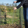Person using a stainless steel compost mixer with a curved cushioned handle inside a wire compost bin outdoors on a sunny day, part of Farm, Garden & Tool, Composting, Garden Accessories, USA Made, and Best Sellers collections.