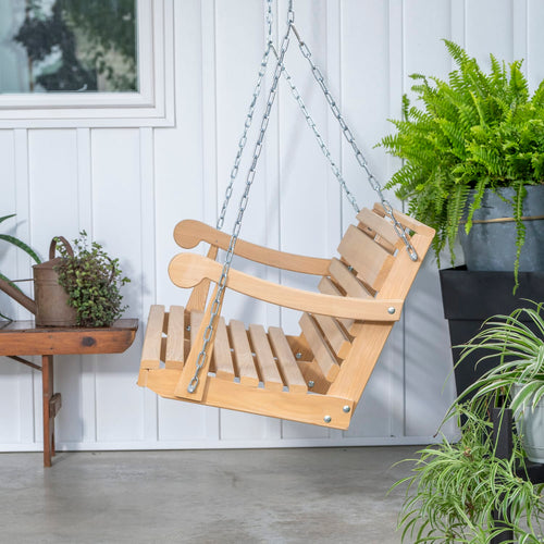 Handcrafted 5-foot cypress porch swing suspended by metal chains, featuring a slanted back and smooth armrests, made in USA for Home & Decor and Outdoor Furniture collections.