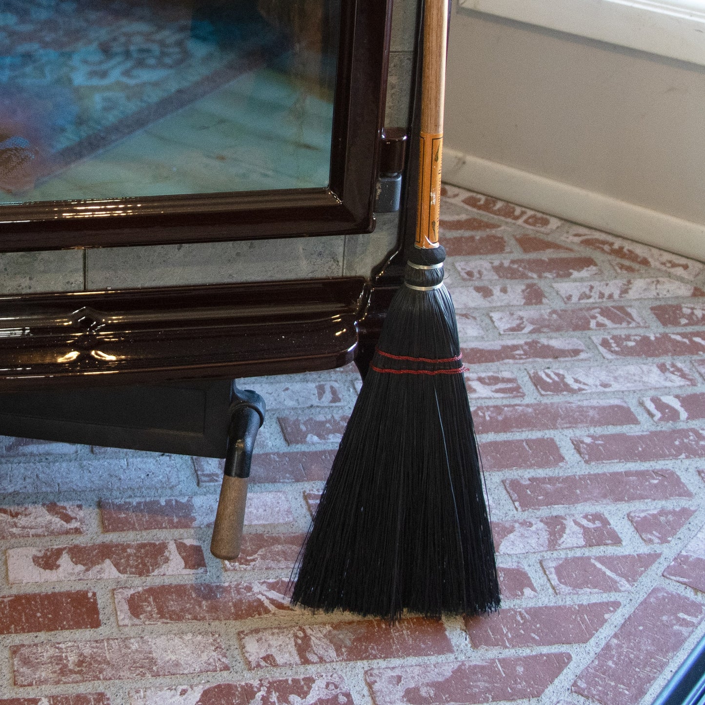 Handcrafted Amish broom with black corn straw bristles and a wooden handle, designed for sweeping ashes near wood stoves and fireplaces, part of USA Made and Hearth Accessories collections.