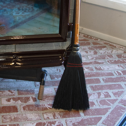 Handcrafted Amish broom with black corn straw bristles and a wooden handle, designed for sweeping ashes near wood stoves and fireplaces, part of USA Made and Hearth Accessories collections.