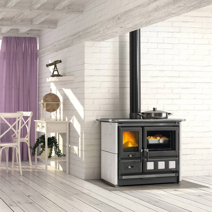 Freestanding wood cook stove with porcelain enameled steel oven door, polished cast iron cooking plates, extractable ash drawer, and cast iron hearth interior, ideal for stoves, cookstoves, best sellers, and all stoves & appliances collections in a bright, modern kitchen.