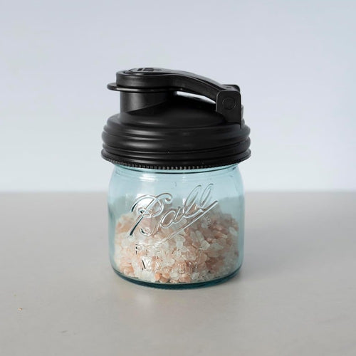 Small clear Ball jar filled with pink salt and fitted with a black pour lid featuring a flip-top spout and carry loop, crafted from durable no-break plastic, ideal for Kitchen & Food and USA Made collections.