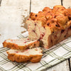 Handcrafted loaf of fresh cherry nut bread with swirls of cherry and pieces of walnut, made in USA, displayed on a green and white checkered cloth in Kitchen & Food collections.
