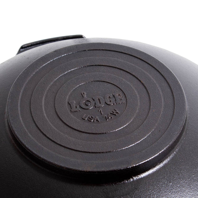 Close-up of the base of a cast iron wok featuring a stamped logo and size, highlighting durable construction and handcrafted quality, ideal for Kitchen & Food, Cast Iron, USA Made, and Best Sellers collections.