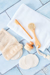 Set of handcrafted grooming tools including a gentle face brush with oiled beechwood handle, soft bristles, reusable cotton pads, and a mesh bag, promoting Health & Wellness, Grooming and Personal Hygiene, Best Sellers, and Promo Eligible collections.