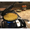 Handcrafted pre-seasoned cast iron waffle maker with detachable halves and special hinge, cooking a round waffle over a gas stove burner, featured in Farm, Garden & Tool and Kitchen & Food collections.