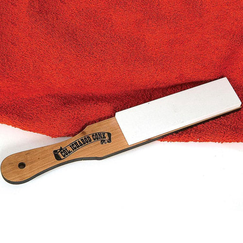 Hard whetstone sharpening stone with a smooth white surface mounted on a hardwood paddle handle, handcrafted in the USA, ideal for grooming and personal hygiene care.