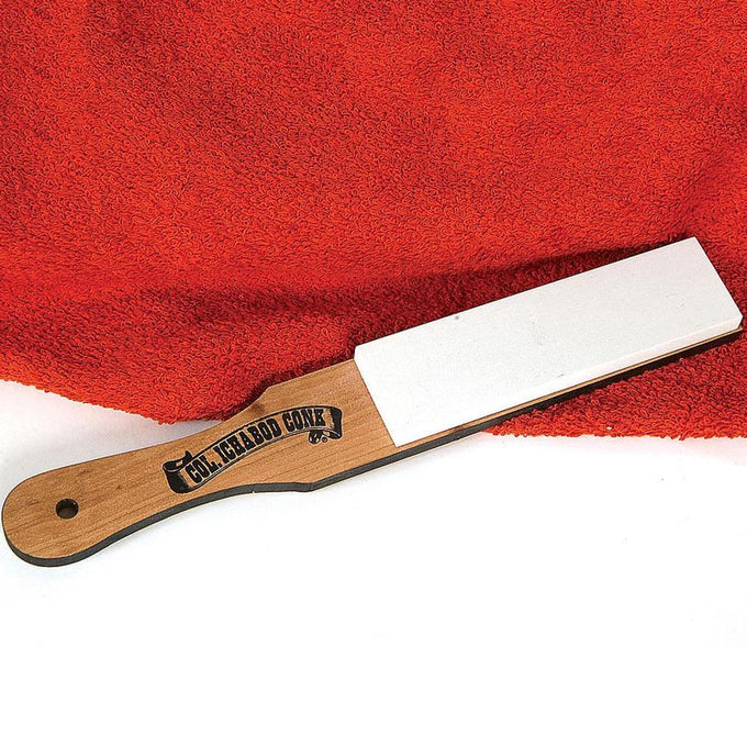 Hard whetstone sharpening stone with a smooth white surface mounted on a hardwood paddle handle, handcrafted in the USA, ideal for grooming and personal hygiene care.