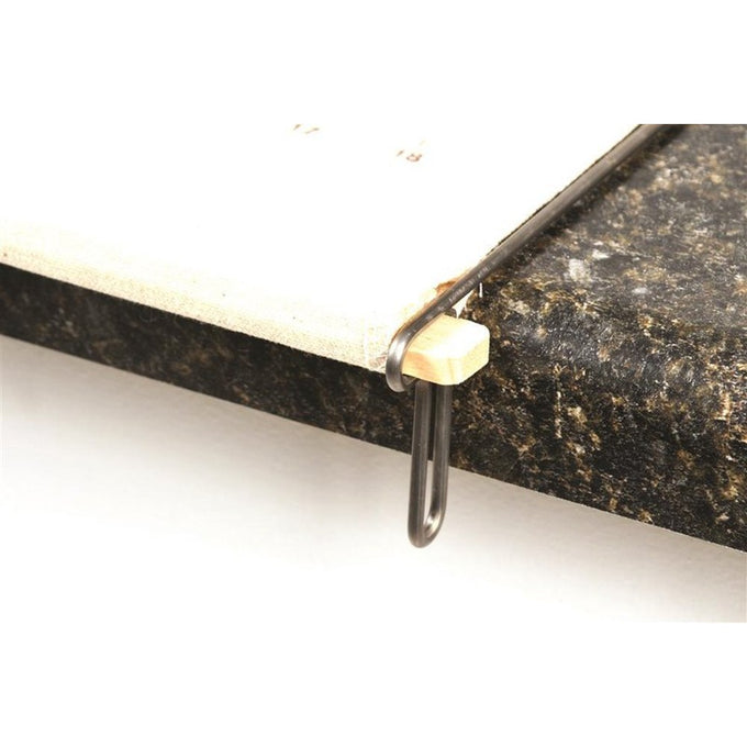 Close-up of wooden slat secured by a long metal loop resting on a dark granite countertop edge, showcasing the pastry frame’s design to stay taut and stable during use, ideal for Kitchen & Food, Cookware, Baking Supplies, Best Sellers, and Promo Eligible collections.