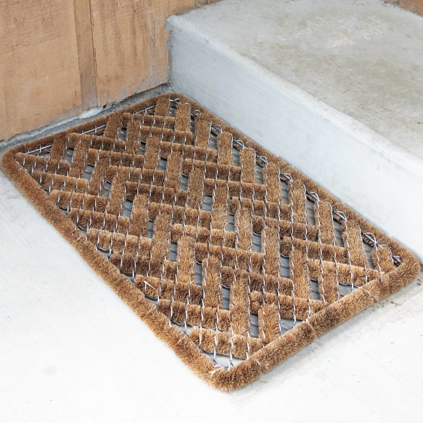Handcrafted bootscraper rug with natural coconut fibers woven into a sturdy wire frame in a geometric pattern, designed for effective dirt removal in Home & Decor and Best Sellers collections.