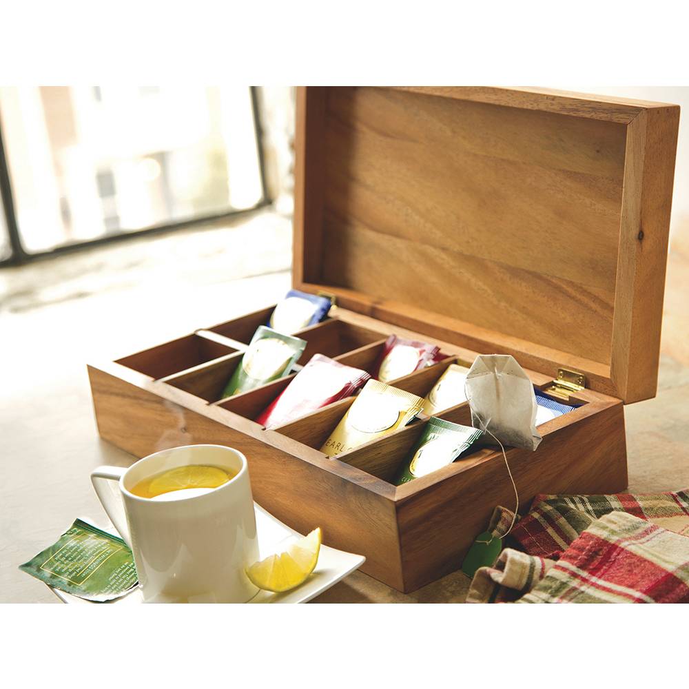 Handcrafted acacia wood tea box with ten compartments holding assorted tea packets, shown open next to a steaming cup of tea with a lemon wedge in Kitchen & Food and Storage collections.