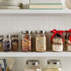 Set of three wide mouth glass jars with stainless steel airtight lids storing dried fruits, oats, and baking mixes, displayed on a white kitchen shelf in Kitchen & Food and Storage collections.