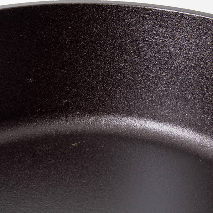 Close-up of the smooth, seasoned surface of a handcrafted cast iron camp Dutch oven, showcasing durable construction ideal for Farm, Garden & Tool, Camping, and Cookware collections.