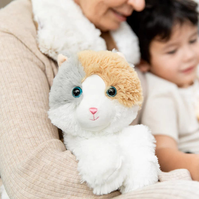 Soft plush cat in calming neutral tones with bright blue eyes, designed for warming comfort, featured in Health & Wellness, Children's Toys, and Indoor Play collections.