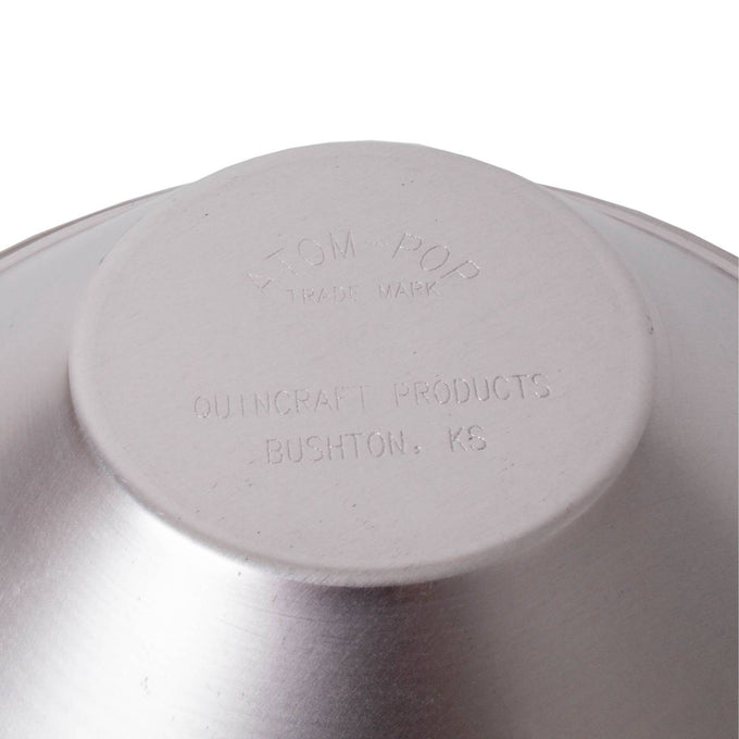 Bottom view of a handcrafted aluminum stovetop popcorn popper with embossed branding and origin from Bushton, Kansas, featured in Kitchen & Food and Cookware collections.
