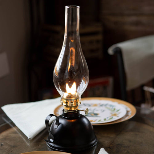 Handcrafted vintage-style oil lamp with a black steel round base, curved handle, clear glass chimney, and brass burner, perfect for Farm, Garden & Tool, Emergency Supplies, and Best Sellers collections.