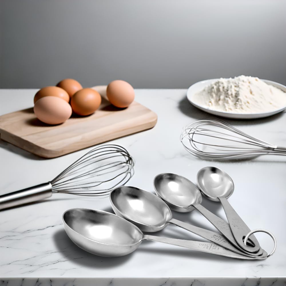 Set of four large stainless steel measuring scoops on a marble countertop with two wire whisks, a plate of flour, and a wooden board holding six brown eggs, ideal for Kitchen & Food, Baking Supplies, and Food Prep collections.