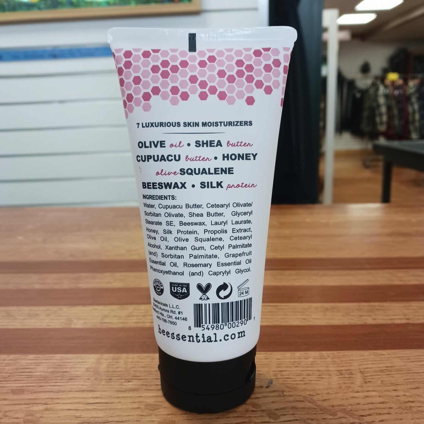 Back view of a 6 fl oz tube of Beessential Hand and Body Cream highlighting natural moisturizers like olive oil, shea butter, honey, beeswax, and silk protein, handcrafted in USA, featured in Health & Wellness, Balms, Creams and Lotions, USA Made, Best Sellers, Promo Eligible, and Sale collections.