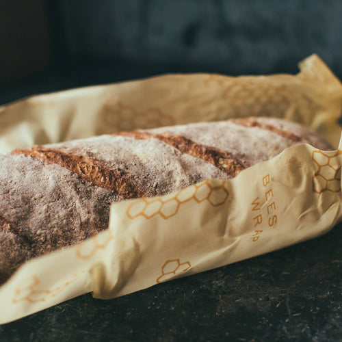 Sourdough loaf wrapped in a partially unrolled beeswax-coated muslin cloth with honeycomb design, handmade in the USA, from Kitchen & Food and Storage and Serving collections.
