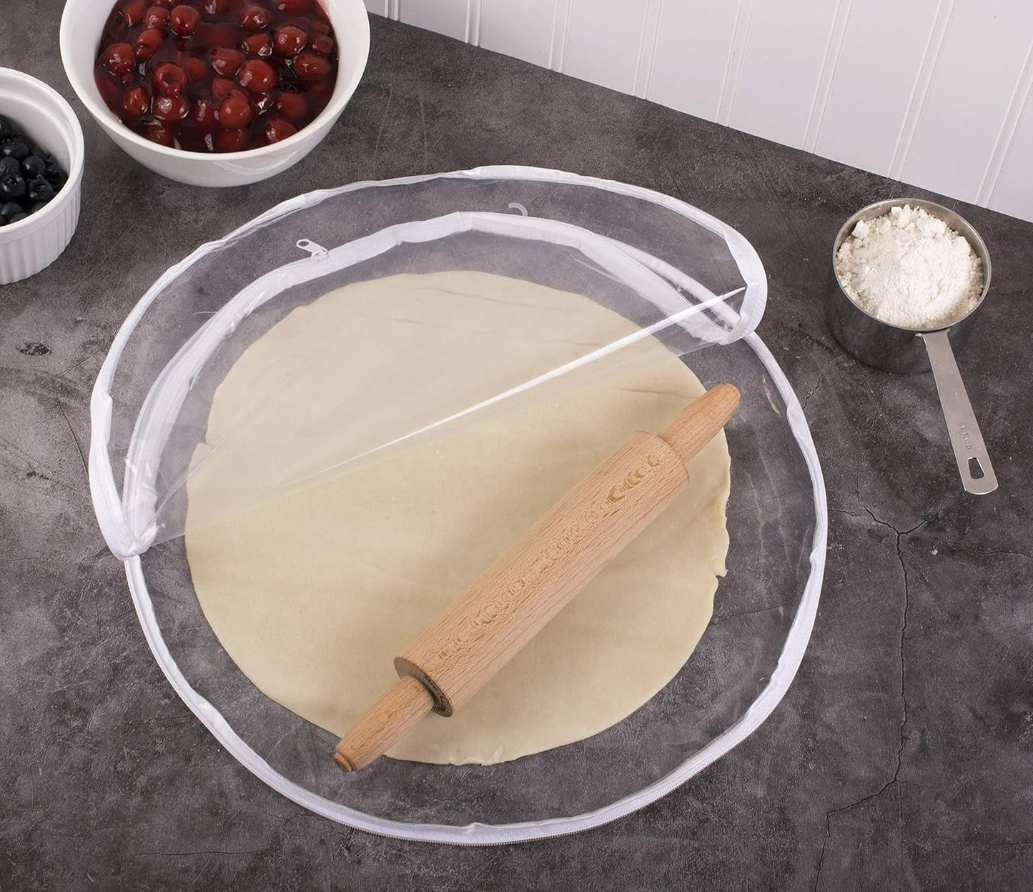 Clear round plastic bag with zipper used to roll out evenly sized pie dough, surrounded by bowls of cherries, blueberries, and flour, ideal for Kitchen & Food, Cookware, Baking Supplies, Best Sellers, and Promo Eligible collections.