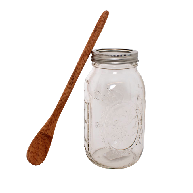 Handcrafted oak jar opener with smooth finish beside a clear mason jar with metal lid, designed to easily release canning jar lids, featured in Kitchen & Food and Canning Accessories collections.