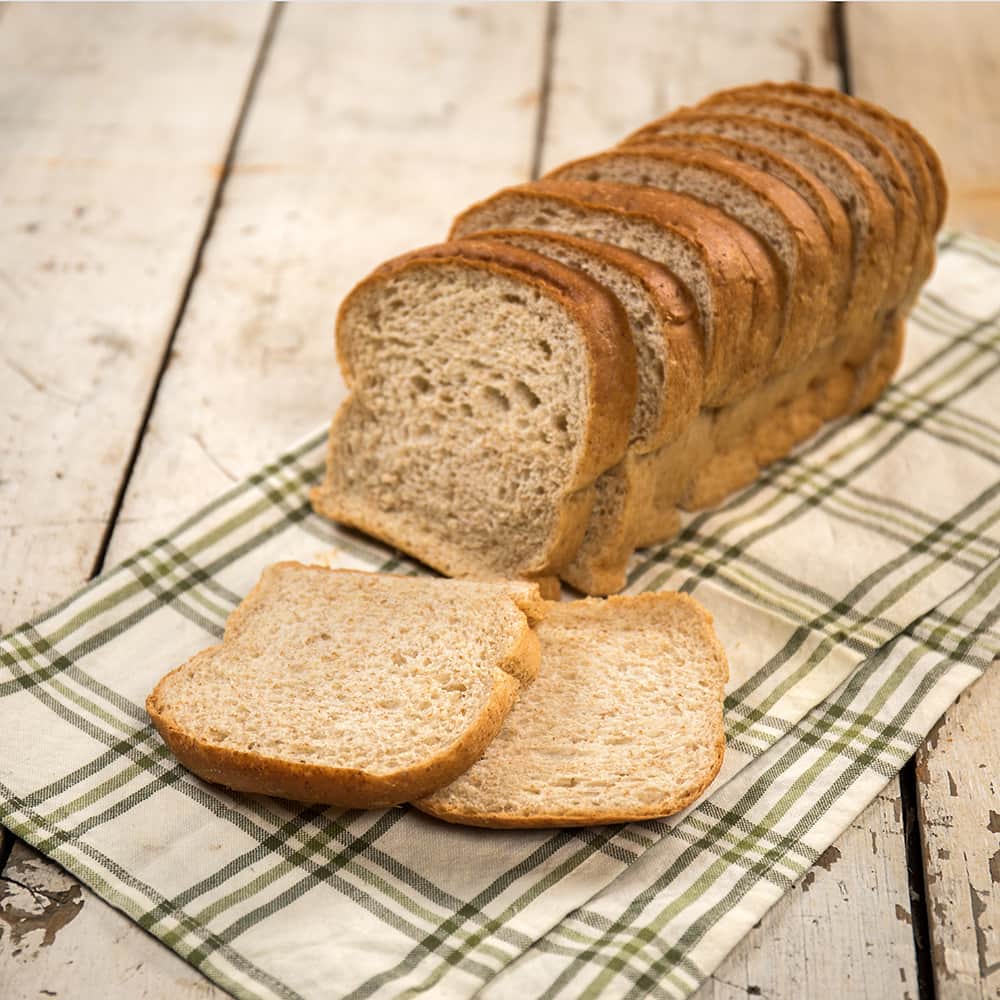 Handcrafted Amish-style bread with thick, soft slices, made in the USA, displayed on a plaid cloth, ideal for Kitchen & Food, Snacks and Sweets, and Best Sellers collections.